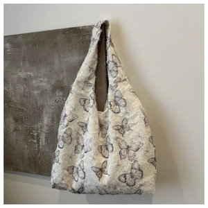 Detailed texture of butterfly print tote bag with fuzzy material and fringe edges