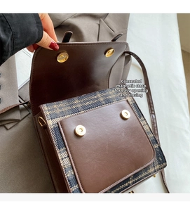 Detail view of the hidden magnetic closure on a British style plaid and leather backpack
