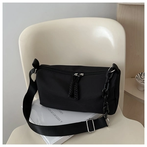 Detail of black nylon crossbody bag with acrylic chain and adjustable fabric strap