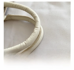 Detail shot of the comfortable cream leather handle on a stylish canvas tote bag