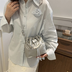 Silver metallic drawstring bucket bag for women with decorative pearl chain handle