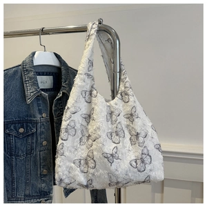 Detailed texture of white canvas bag with fuzzy butterfly prints and wide shoulder strap
