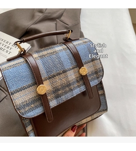 Detail of British style plaid backpack with brown leather trim and golden metal buckles