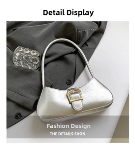 Close-up of silver hobo bag with gold buckle on grey blazer with a glass prop