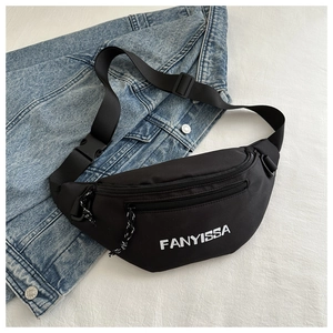 Detail of black sporty crossbody bag with white lettering on light blue denim jacket