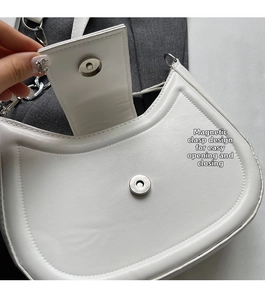 Détail de la fermeture magnétique d'un sac à bandoulière en similicuir blanc en croissant