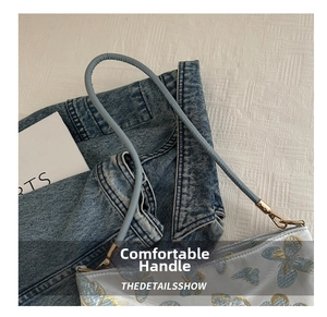 Détail du sac cabas bleu clair avec broderie papillon dorée et fines lanières