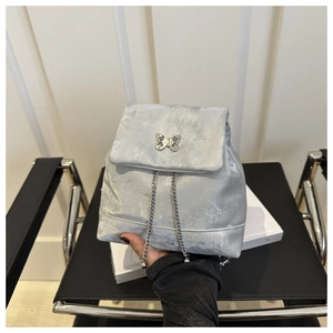 Detail of silver velvet mini backpack with metal butterfly buckle and chain strap