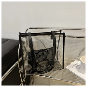 Détail du sac cabas transparent en PVC avec bordures noires et une pochette à motif d'ours