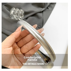 Detail of silver patent leather handle with smooth metallic finish and fine stitching