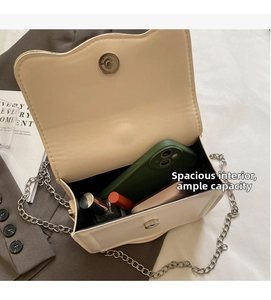 Detail view of cream white flap bag interior showing capacity for phone and lipstick