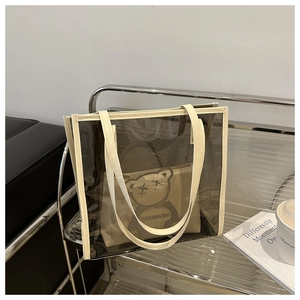 Détail du sac cabas transparent en PVC avec bordure en cuir blanc et pochette ours interne
