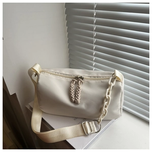 Detail of cream white canvas crossbody bag with acrylic chain and textured fabric strap
