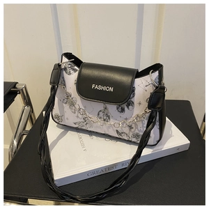 Detail of trendy black and white shoulder bag with butterfly print and floral silver chain
