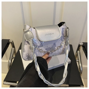 Detail of silver flap handbag featuring purple butterfly print and FASHION lettering