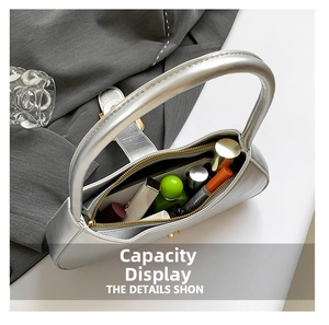Internal view of silver patent leather bag showing capacity for cosmetics and gold zipper