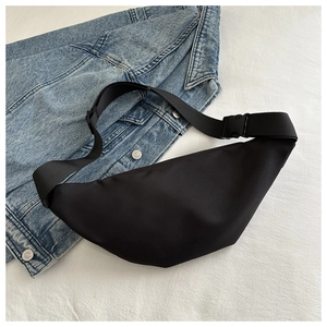 Minimalist black nylon crossbody bag on a denim jacket for a casual everyday style