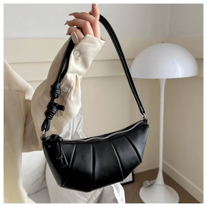 Détails des plis verticaux et de la bandoulière nouée du sac à bandoulière noir
