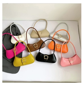 Flat lay of multiple color patent leather baguette bags with large metal buckles