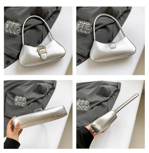 Detail view of silver metallic crescent bag with gold buckle and pleated texture detail