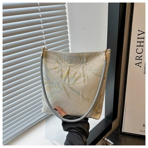 Détail de broderie en soie dorée sur tissu jacquard avec motifs de feuilles de bambou