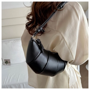 Détail du sac croissant noir en cuir avec bandoulière nouée et design plissé