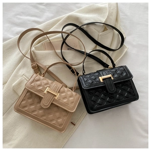 Detail of khaki and black quilted crossbody bags with gold hardware and top handles