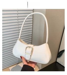Detail of white patent leather baguette bag featuring a large gold buckle and strap