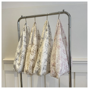Detailed view of canvas tote bags with butterfly patterns and frayed fringe edges