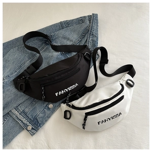Detail of nylon dumpling crossbody bags with Fanyissa logo on blue denim jacket