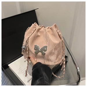 Détail du sac seau rose à texture marbrée avec boucle papillon en métal argenté