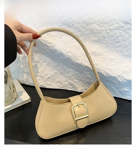 Detail view of khaki patent leather shoulder bag with golden buckle and sleek strap