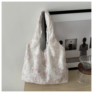 Detail of white plush canvas tote bag featuring textured fabric and pink butterfly prints
