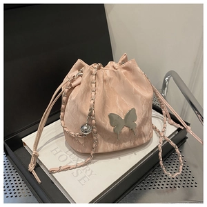 Vue détaillée du sac seau rose marbré avec papillon argenté et bandoulière en chaîne