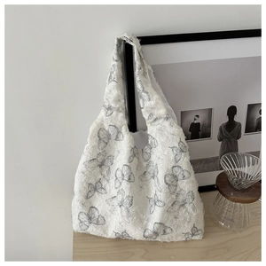 Detail of white canvas tote bag with gray butterfly embroidery and fringe frayed edges