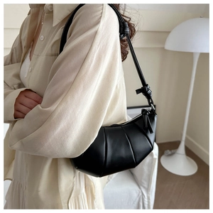 Gros plan du sac croissant noir avec détails plissés et bandoulière nouée réglable