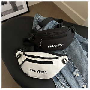 Close-up of black and white nylon crossbody bags with logo on denim background