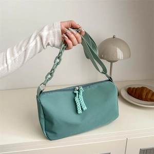 Minimalist mint green canvas crossbody bag with decorative plastic chain strap detail
