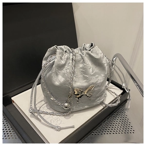Détail du sac seau argenté plissé avec pendentif papillon et bandoulière chaîne