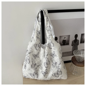 Detail shot of the plush textured fabric and grey butterfly print on this white tote bag
