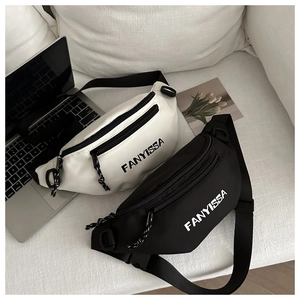 Minimalist black and white Oxford fabric crossbody bags set on a sofa with a laptop