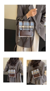 Detail of British style checkered backpack with brown leather flap and metal button closure