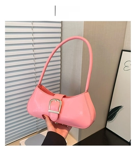 Detail of pink glossy shoulder bag with slender strap and metallic buckle decoration