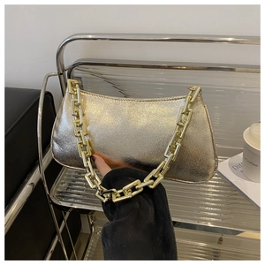 Vue détaillée du sac à bandoulière doré brillant avec bandoulière à chaîne géométrique