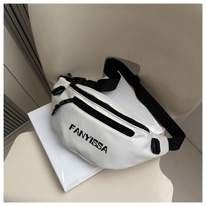 Detail of white FANYISSA sling bag with black zippers and adjustable strap on a chair