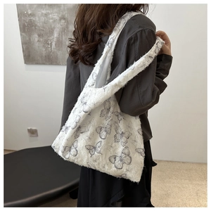Detailed side view of white canvas tote bag with butterfly prints and distressed edges