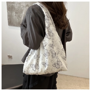Detail of white chiffon tote bag with butterfly embroidery and frayed edge texture