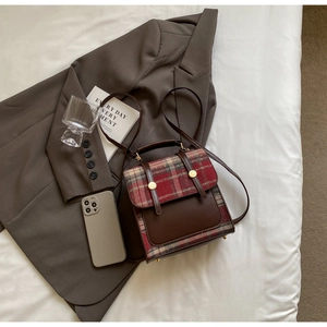 Detail of vintage British style backpack with tartan flap and gold metallic buckles