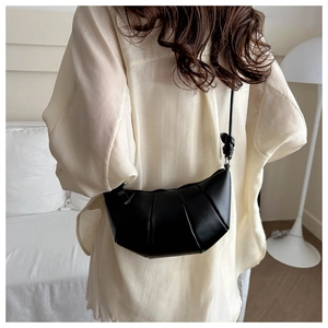 Détail du sac croissant noir avec texture plissée et bandoulière à nœud réglable