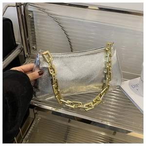 Détail du sac argenté avec texture craquelée brillante et bandoulière chaîne dorée